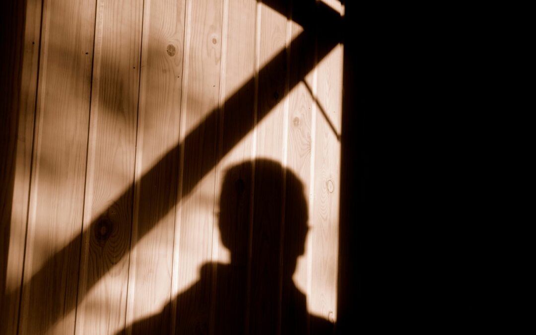 The shadow of a man lurking near a garage, showing the need for garage door security