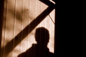 The shadow of a man lurking near a garage, showing the need for garage door security